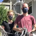 A man and woman holding telecom wires that WIre Free Sky removed from their home