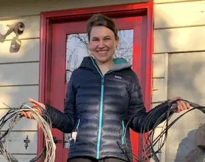 Photo of a woman holding up coils of telecom wire WIre Free Sky removed from her home
