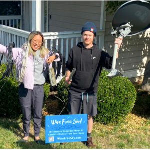 Couple with coils of telecom wire and a satellite dish just removed from house