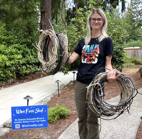 Woman in garden holding 2 coils of wire that were just removed from the sky