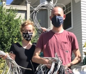 A man and woman holding telecom wires that WIre Free Sky removed from their home