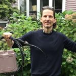 Man holding telecom wires and service boxes that Wire Free Sky removed from his home