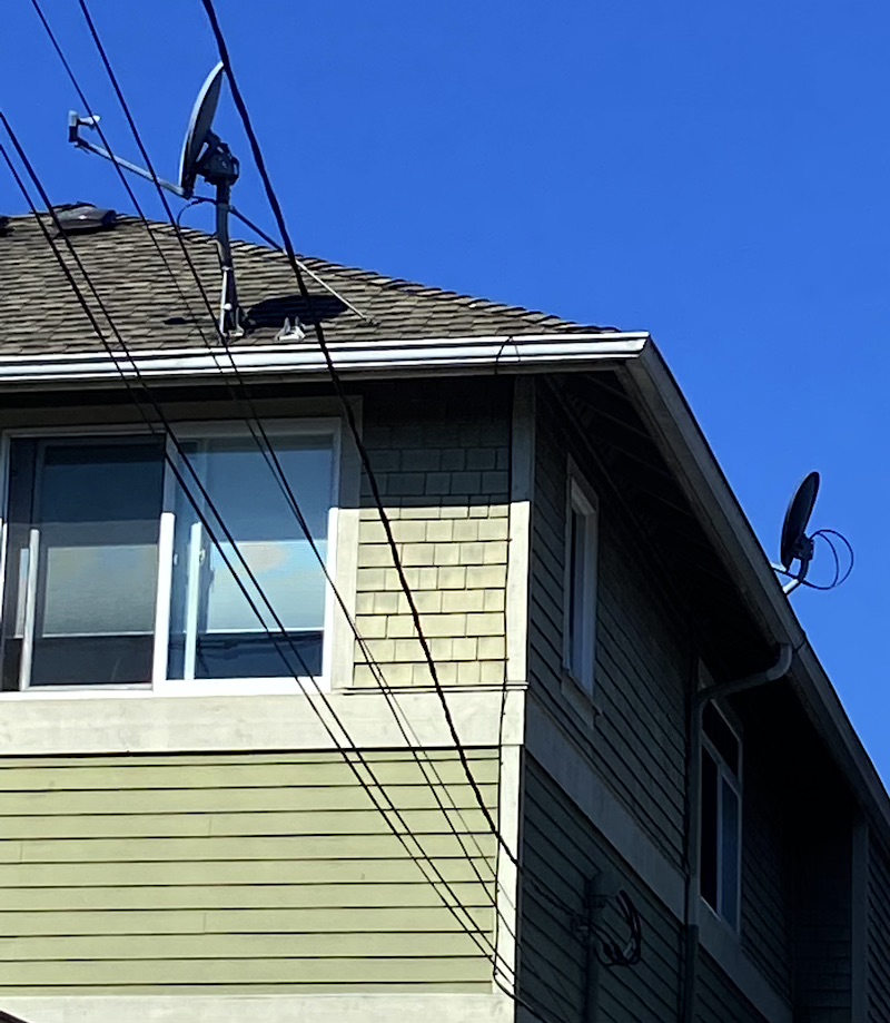 green house with 2 satellite dishes on the roof