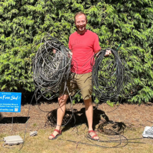 A happy man with all the coils of wire that were removed from his house
